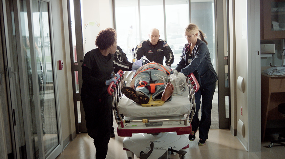 professionals helping someone on a stretcher